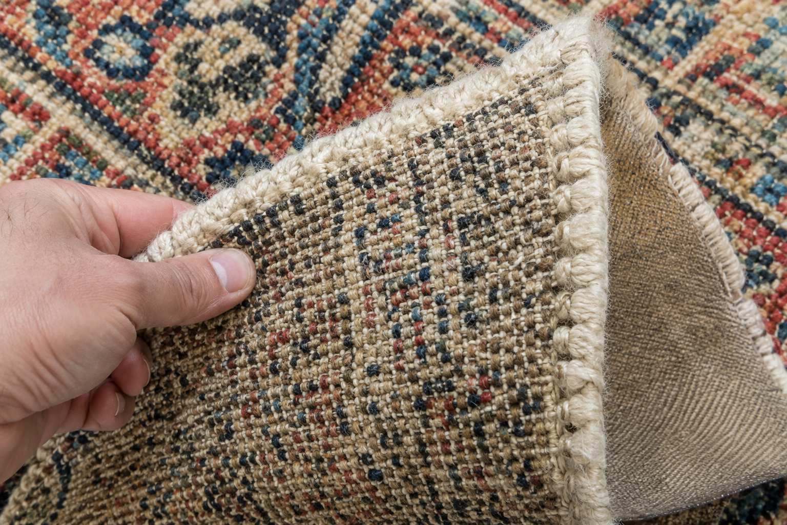 Close-up photo of a rug being turned over to show its underside